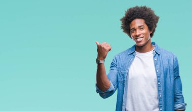 Seyir ve başparmak yanında yukarıyı mutlu yüz ile gülümseyen izole arka plan üzerinde Afro Amerikalı adam.
