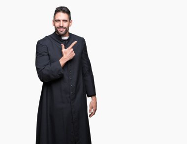 Genç Hıristiyan rahip izole arka neşeli bir gülümseme ile el ve parmak kadar yan yüzünde mutlu ve doğal ifade ile işaret yüz üzerinden