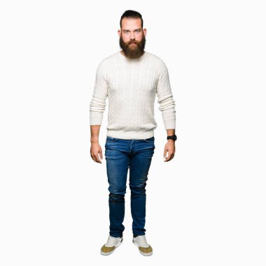 Kış kazak gevşek ciddi ifade ile yüzünde giyen genç hipster adam. Basit ve doğal kameraya bakıyor.