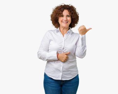 Seyir ve başparmak yanında yukarıyı mutlu yüz ile gülümseyen izole arka plan güzel orta ager üst düzey businees kadın.