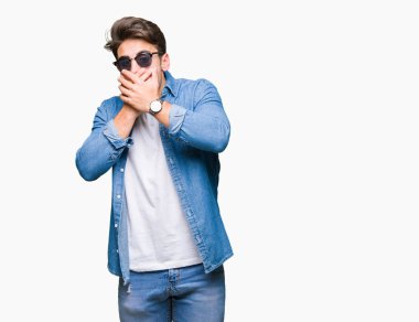 Yakışıklı delikanlı üzerinde güneş gözlüğü takıyor arka plan ağız hata için elleriyle kapsayan şok izole. Gizli kavramı.