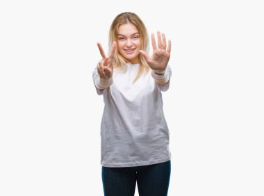 Gösterilen ve parmakları ile işaret izole arka plan üzerinde beyaz kadın kendinden emin ve mutlu gülümseyerek süre yedi numara.
