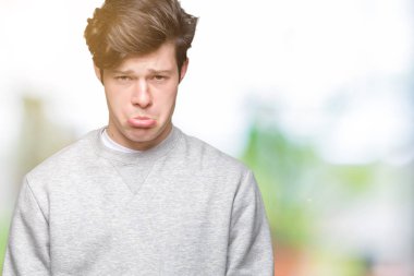 Genç yakışıklı sportif adam kazak giyiyor izole arka plan üzerinde depresif ve kızgın ve korkmuş ağlıyor sıkıntı için endişeleniyorum. Üzgün ifade.