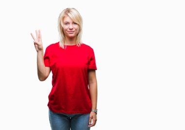 Gösterilen ve parmakları ile işaret izole arka plan üzerinde kırmızı t-shirt giyen genç güzel sarışın kadın kendinden emin ve mutlu gülümseyerek iken üçüncü.