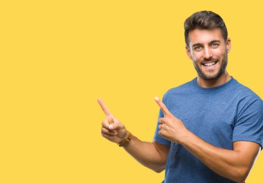 Yakışıklı delikanlı gülümseyen ve iki elleri ve parmakları ile tarafına işaret kamera bakarak izole arka plan üzerinde.