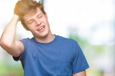 El hareketi ile kendine güvenen dokunaklı saç gülümseyerek, çekici poz izole arka plan üzerinde mavi t-shirt giyen genç yakışıklı adam