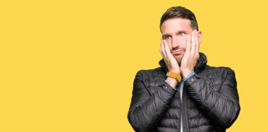 Kış ceket yorgun el yüz, depresyon ve üzüntü, kapsayan giyen yakışıklı adam üzgün ve sorun için tahriş