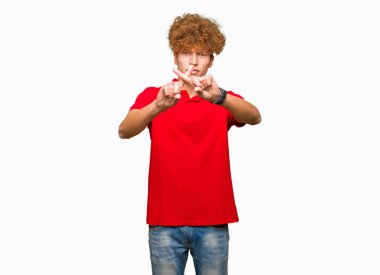 Kırmızı t-shirt giyen afro saçlı yakışıklı delikanlı ret ifade geçiş parmakları eksi işareti yapıyor