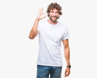 İzole arka plan el ve parmaklar ok işaretiyle yapıyor olumlu gülümseyen üzerinden yakışıklı İspanyol modeli adam. Başarılı ifade.
