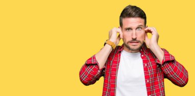 Yakışıklı adam yüksek sesle müzik gürültü rahatsız ifade parmaklarıyla kulaklarıyla kapsayan geçici gömlek giymiş. Sağır kavramı.