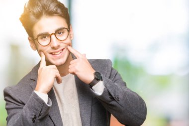Genç iş adamı gözlük izole üzerinde gülen arka plan açık ağız ile parmak işaret ve neşeli gülümseme zorlamadan