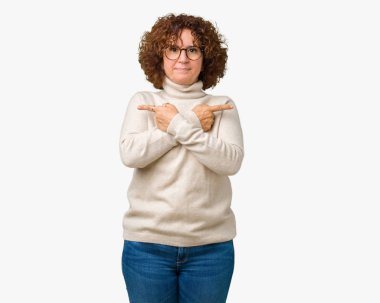 Arka plan güzel orta ager kadın kıdemli giyen boğazlı kazak ve gözlük izole üzerinde işaretleme için her iki parmak, farklı yönde ile katılmıyorum