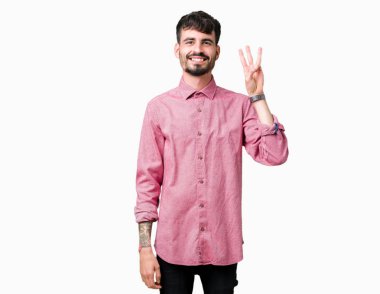 Gösterilen ve parmakları ile işaret izole arka plan üzerinde pembe gömlek giymiş genç yakışıklı adam kendinden emin ve mutlu gülümseyerek iken üçüncü.