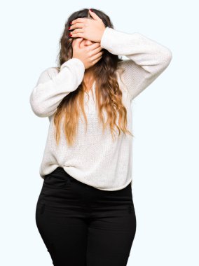 Beyaz kazak kapsayan gözler ve ağız el ile giyen genç güzel kadın şaşırttı ve şok. Duygu gizleme