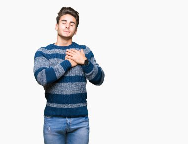 Yakışıklı delikanlı ile gülümseyen izole arka plan üzerinde kapalı gözler ve yüzünde minnettar jest ile göğüs üzerinde eller. Sağlık kavramı.