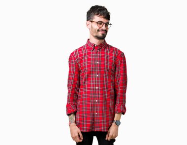 Uzak tarafına yüzünde, doğal ifade gülümseme ile seyir izole arka plan üzerinde gözlük takan yakışıklı delikanlı. Kendine güvenen gülüyor.