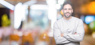 Üzerine tişört giyen genç yakışıklı adam mutlu yüz ile gülümseyerek kameraya seyir silah geçti arka plan izole. Olumlu bir kişi.