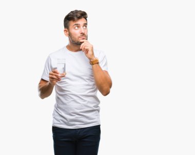 Yakışıklı delikanlı izole arka plan ciddi bir yüz düşünme hakkında soru, çok karışık bir fikir üzerinde bardak su içme