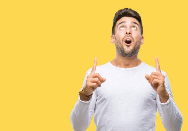 Yakışıklı delikanlı izole arka plan üzerinden hayran ve yukarıya bakıp parmakları ile işaret şaşırttı ve silah kaldırdı.