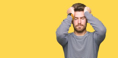 Genç yakışıklı adam giyen çizgili süveter çünkü umutsuz ve stresli baş ağrısı acı acı ve migren. Ellerini kafasına.