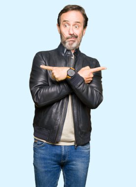 Siyah deri giyen orta yaş yakışıklı adam ceket işaret parmakları ile her iki taraf için farklı yönde katılmıyorum