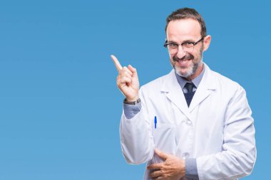 Kameraya bakarak yan el ve parmak ile işaret yüzünde kocaman bir gülümseme ile izole arka plan üzerinde beyaz önlük giyen orta yaş üst düzey ağarmış profesyonel adam.