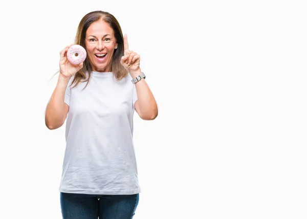 Mujer Hispana Mediana Edad Comiendo Rosquilla Sobre Fondo Aislado Sorprendida —  Fotos de Stock