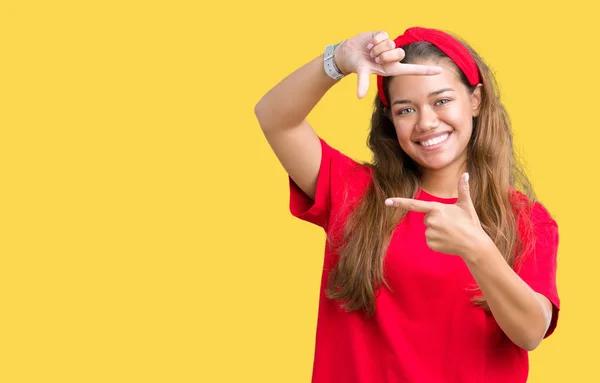 年轻美丽的黑发女人穿着红色的 T恤在孤立的背景微笑的框架与手和手指与快乐的脸 创意和摄影理念 — 图库照片