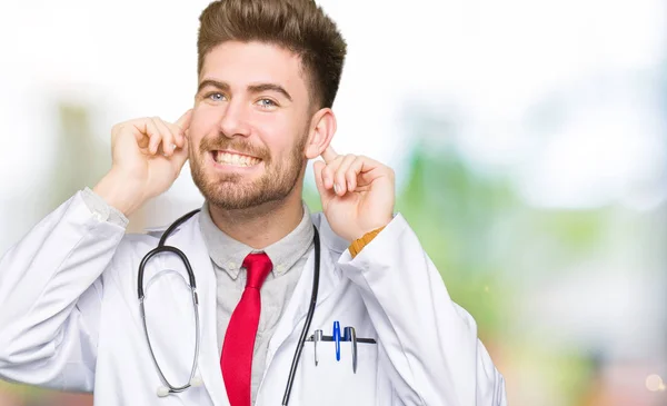 Молодий Красивий Лікар Чоловік Медичному Пальто Усміхаючись Тягне Вуха Пальцями — стокове фото