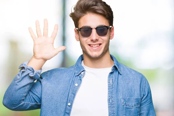 Homem Bonito Jovem Usando Óculos Sol Sobre Fundo Isolado Mostrando — Fotografia de Stock