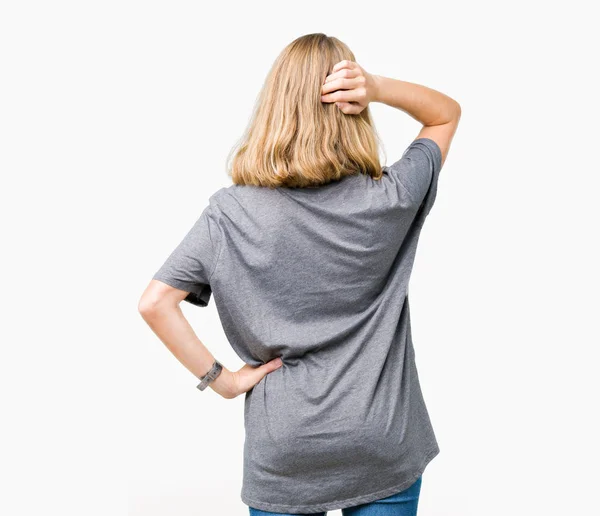 美丽的年轻女子穿着超大尺寸的休闲 T恤在孤立的背景向后思考怀疑与手在头上 — 图库照片