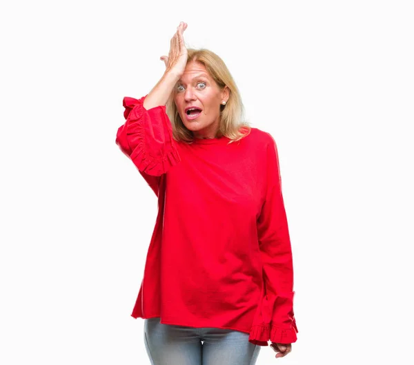 Middle age blonde woman over isolated background surprised with hand on head for mistake, remember error. Forgot, bad memory concept.