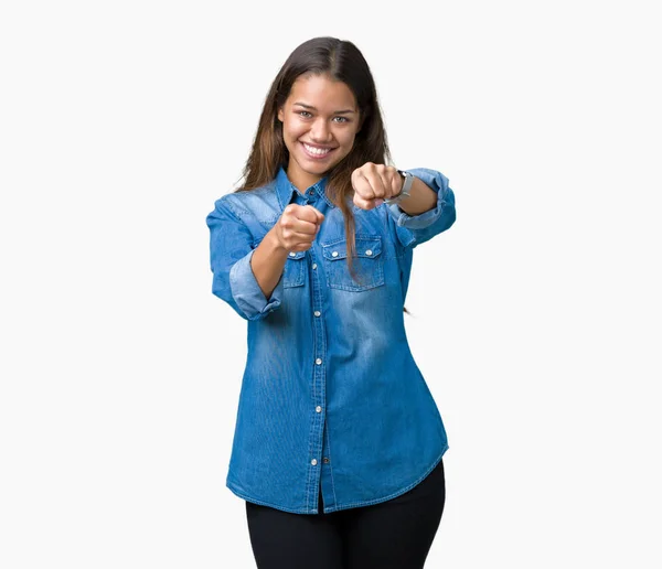 年轻美丽的黑发女人穿着蓝色粗斜纹棉布衬衫在孤立的背景拳打脚踢拳头战斗 侵略性和愤怒的攻击 威胁和暴力 — 图库照片