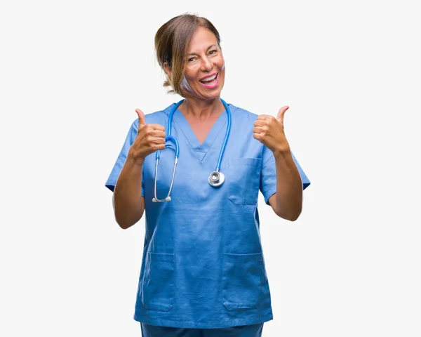 中年资深护士医生妇女在孤立的背景成功标志做积极的手势用手 竖起大拇指微笑和快乐 带着欢快的表情 获胜者的手势看着镜头 — 图库照片