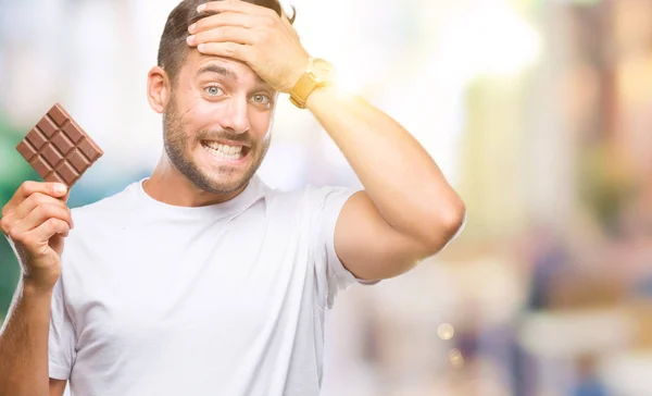 Joven Hombre Guapo Comiendo Barra Chocolate Sobre Fondo Aislado Estresado —  Fotos de Stock