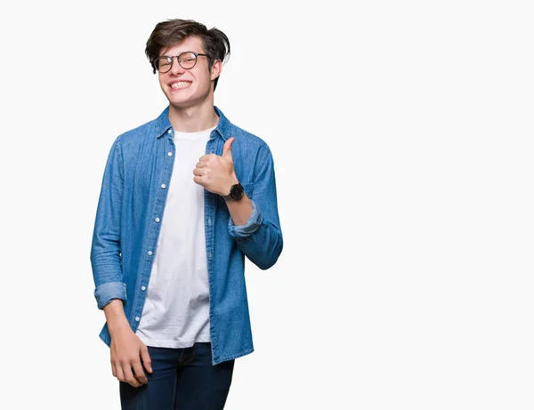 年轻英俊的男人戴着眼镜在孤立的背景做快乐的大拇指用手的手势 查看显示成功的相机的审批表情 — 图库照片