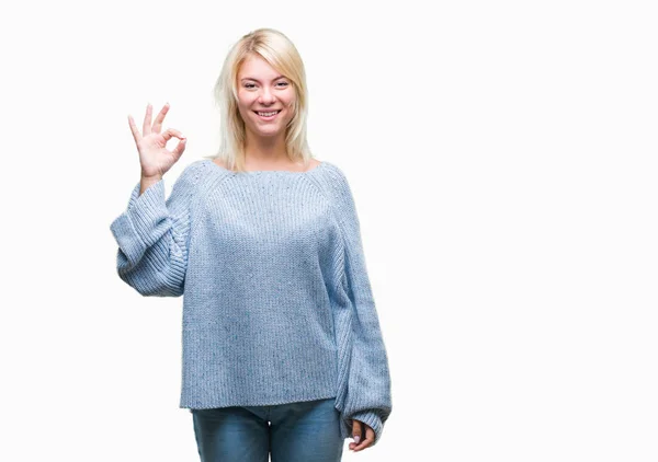 若い美しい金髪女性の孤立した背景を浮かべて手と指で サインをしている肯定的な上冬のセーターを着ています 成功した式 — ストック写真
