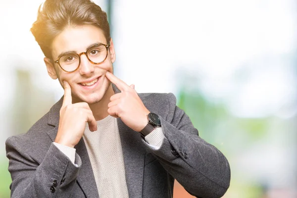 若いビジネス人が分離で眼鏡をかけて背景笑顔口を開けて 指を指すと 陽気な笑顔を強制 — ストック写真