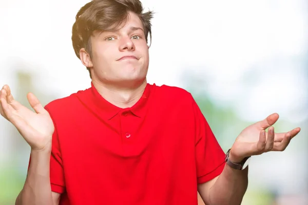 Młody Przystojny Mężczyzna Sobie Czerwony Shirt Przez Wyrażenie Clueless Mylić — Zdjęcie stockowe