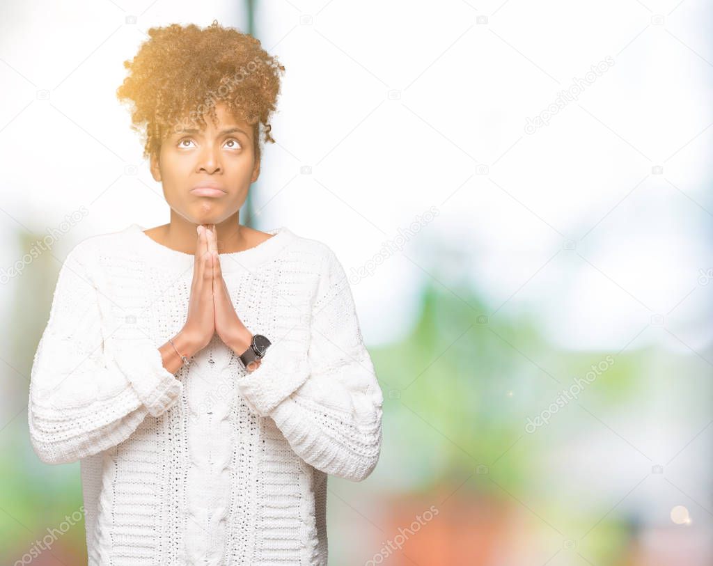 Beautiful young african american woman wearing winter sweater over isolated background begging and praying with hands together with hope expression on face very emotional and worried. Asking for forgiveness. Religion concept.