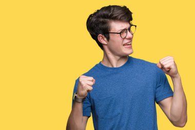 Gülümseyen ve başarı için çığlık izole arka plan çok mutlu ve heyecanlı kaldırdı, silah ile kazanan jest yapıyor üzerinde gözlük takan yakışıklı delikanlı. Kutlama kavramı.