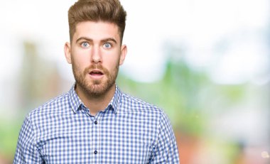 Genç yakışıklı bussines adam korkuyor ve sürpriz ifade, korku ve heyecan yüz ile şok.