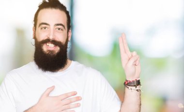 Uzun saç ve sakal bir sadakat sözü yemin yapma rahat beyaz t-shirt Swearing göğüs ve parmaklar, el ile giyen genç hipster adamla