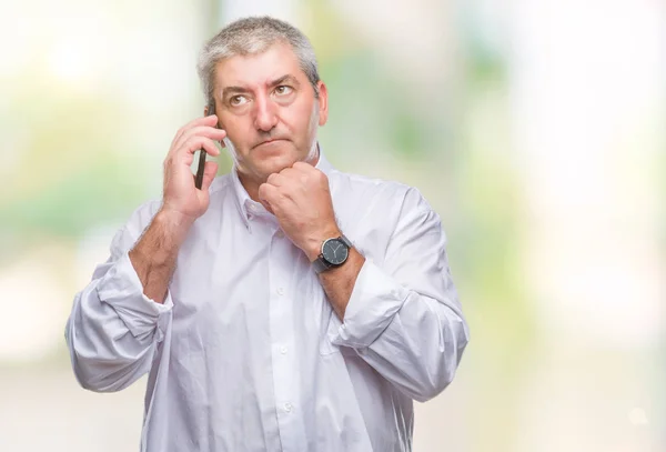 Handsome senior man talking on smartphone over isolated background serious face thinking about question, very confused idea