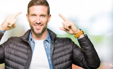 Her iki el parmağı, harika bir fikir ile baş gösteren gülümseyen ya da düşünce kış ceket giyen yakışıklı adam, iyi hafıza