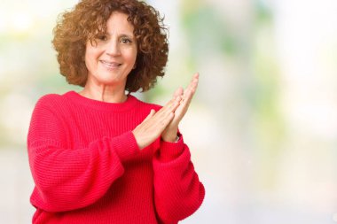 Güzel orta ager üst düzey kadın kırmızı kış kazak izole üzerinde arka plan Clapping ve mutlu ve neşeli, gururlu gülümseyen birlikte eller alkış
