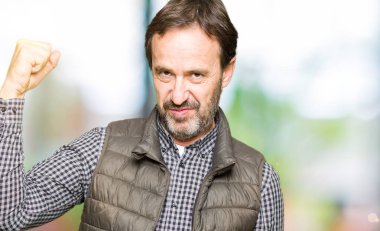 Kış yelek güçlü kişi gösteren kol kas, kendinden emin ve güç gurur giyen orta yaş yakışıklı adam