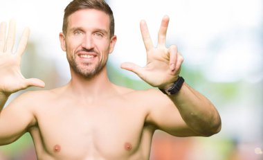 Çıplak göğüs gösterme ve parmakları ile işaret gösterilen yakışıklı gömleksiz adam kendinden emin ve mutlu gülümseyerek süre sekiz numara.