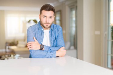 Yakışıklı delikanlı ev şüpheci ve sinir, onaylamayan ifade yüz çapraz kolları üzerinde. Negatif kişi.