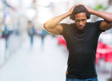Afro Amerikalı adam çünkü umutsuz ve stresli baş ağrısı acı izole arka plan üzerinde ağrı ve migren. Ellerini kafasına.